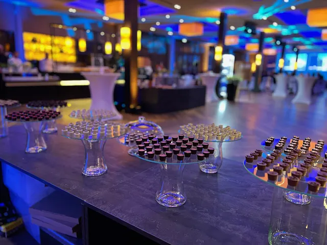 Bonbon stands in an event hall in the evening